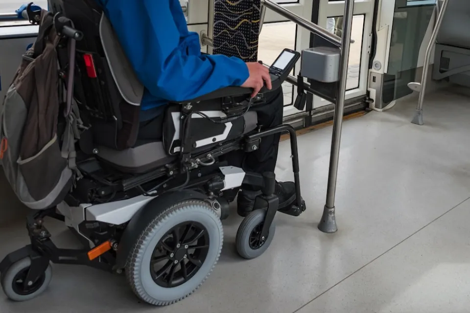 Man in wheelchair in designated area on public bus.